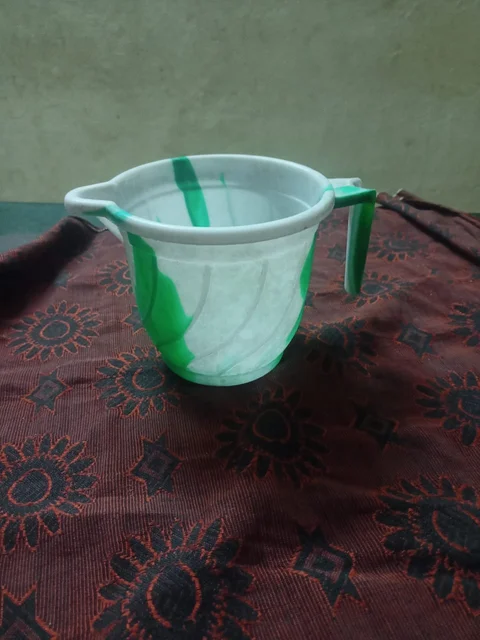 Licensed cup photograph before automatic removal; patterned fabric crosses behind the handle